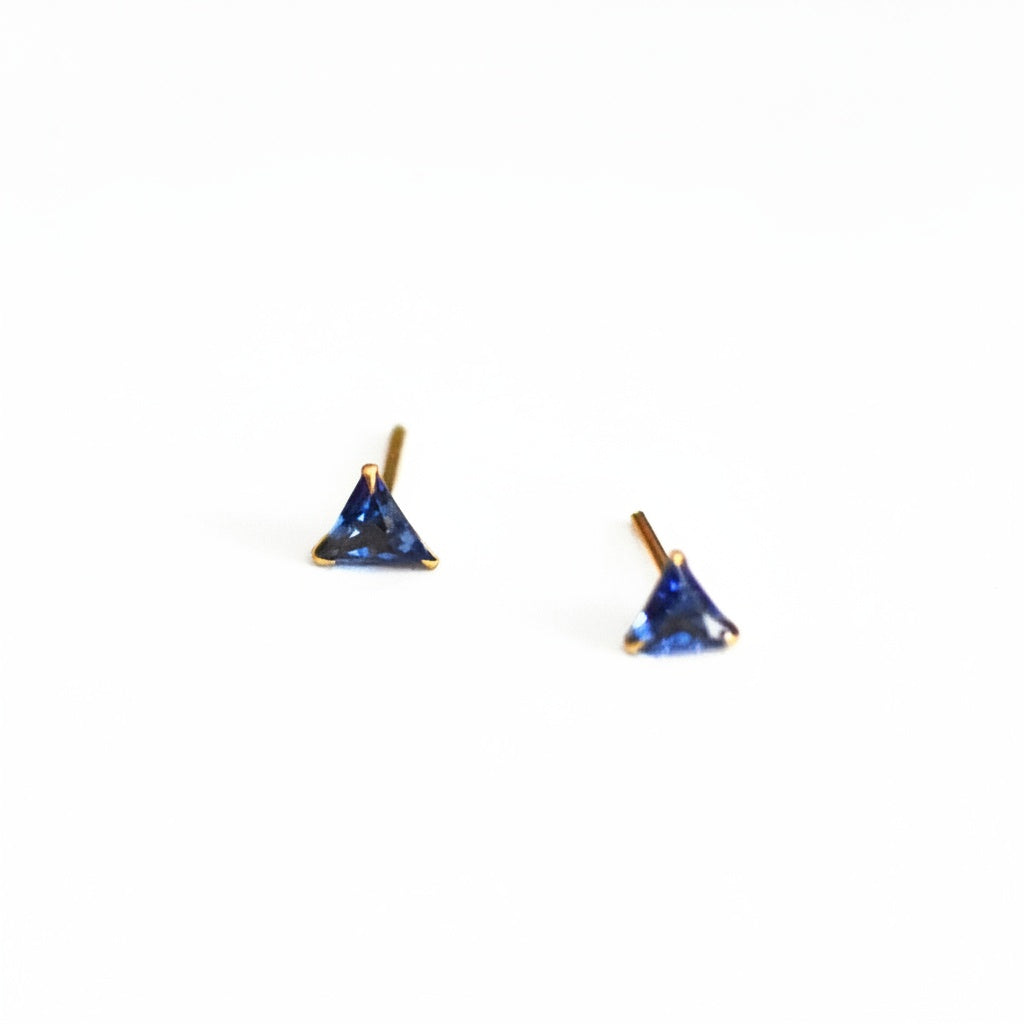brai -Pair of triangle-shaped blue gemstone earrings on a white background